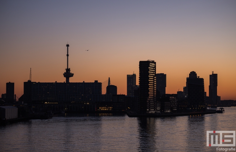 De zonsondergang in Rotterdam met de Erasmusbrug en de Lloydkade