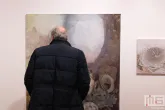 Een schilderij van Jochem Mestriner met bezoeker tijdens Art Rotterdam in de Van Nelle Fabriek in Rotterdam