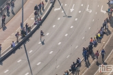 De eerste lopers van de Marathon Rotterdam op de terugweg richting de Coolsingel in Rotterdam