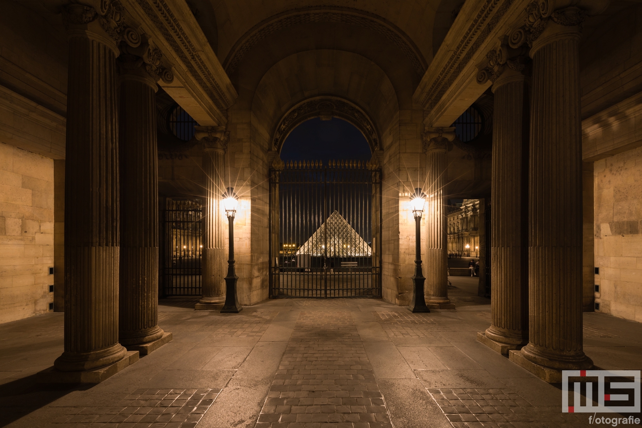 Te Koop | De zuilen en poort van het Louvre Museum in Parijs in nachtelijke uren