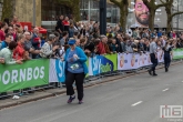 De laatste loper van de NN Marathon Rotterdam op de Coolsingel in Rotterdam