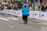 De laatste loper van de NN Marathon Rotterdam op de Coolsingel in Rotterdam