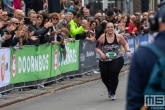 De laatste loper van de NN Marathon Rotterdam op de Coolsingel in Rotterdam