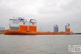 Het half-afzinkbaar transportschip Dockwise Vanguard met sleepboot Thamesbank op de Maas in Rotterdam