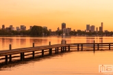 Te Koop | Het uitzicht op de skyline van Rotterdam vanaf de Kralingseplas tijdens zonsondergang